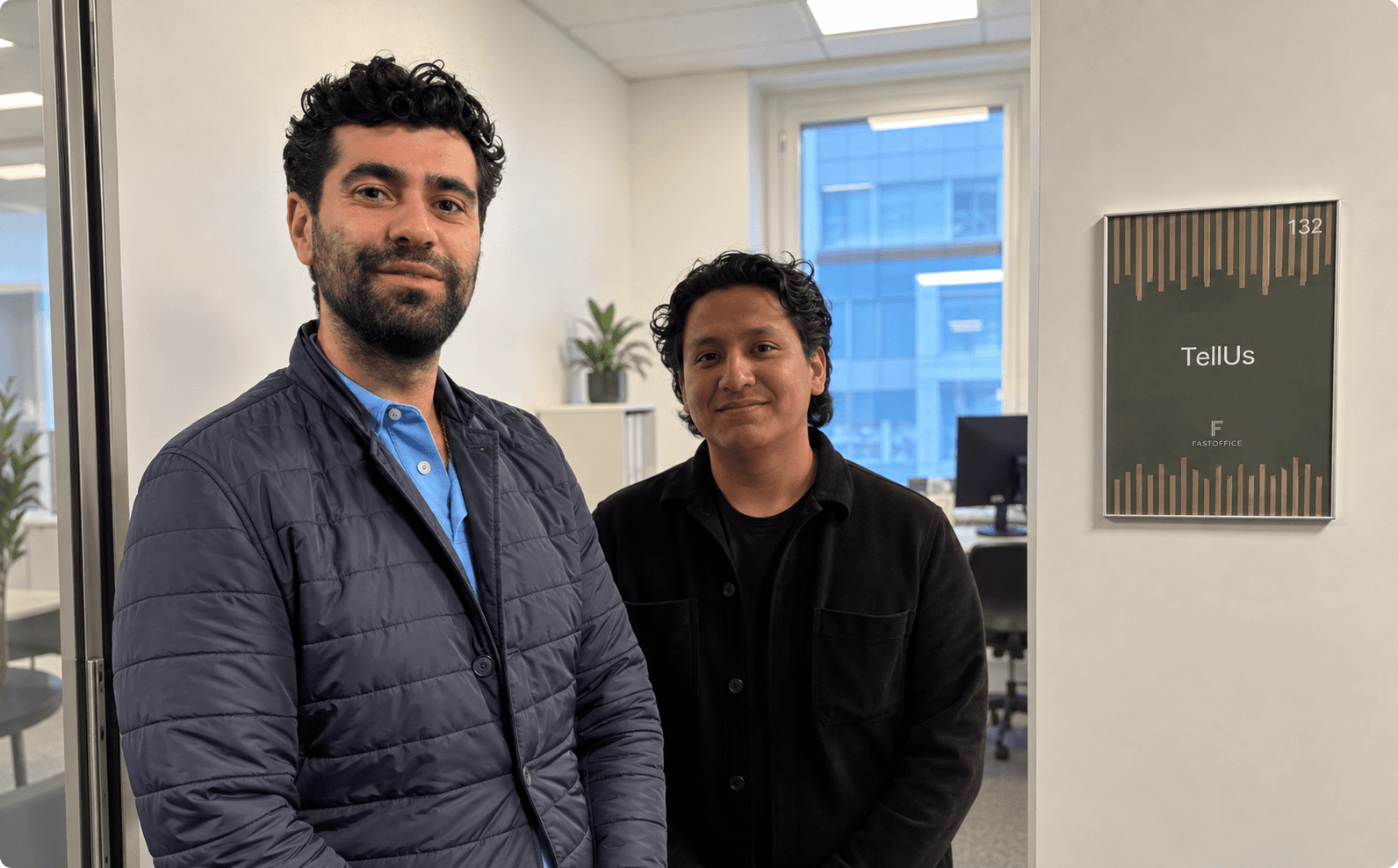 Två personer vid skylten utanför TellUs Swedens kontor